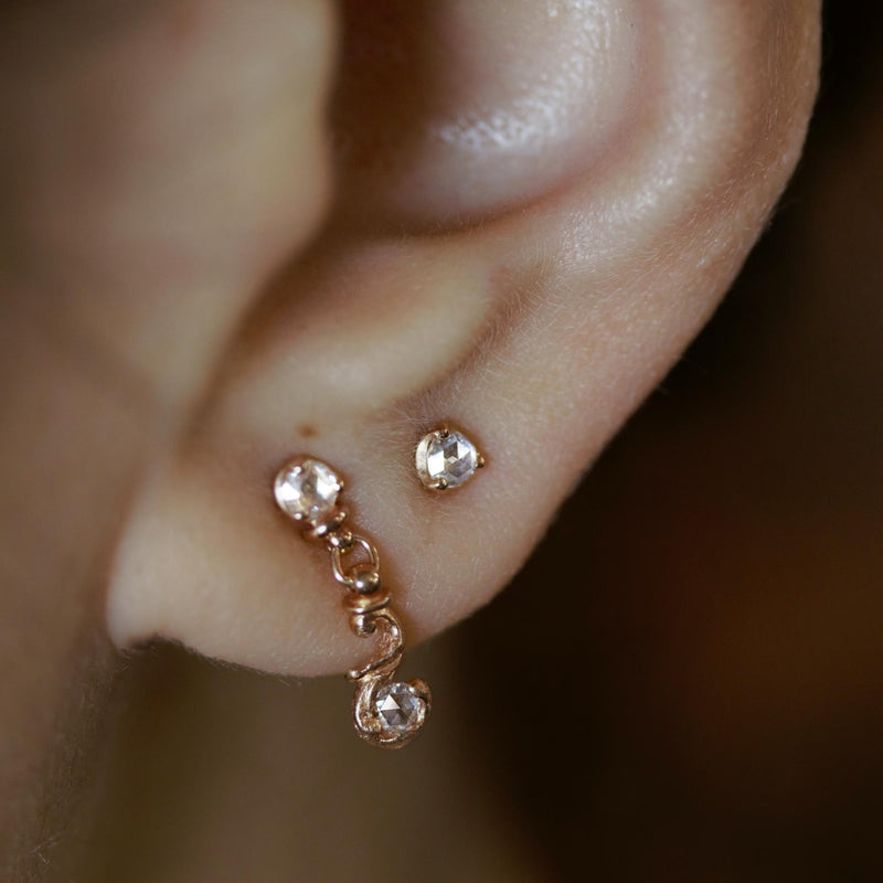 Rose gold stud earring featuring a 2.5mm rose cut diamond. Hand made and finished. Worn on earring.